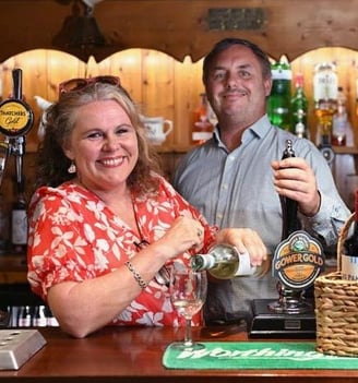 a man and woman standing at a bar