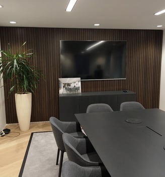 Large TV mounted on a wall in a boardroom