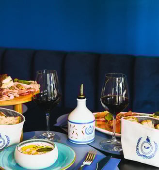a table with a variety of food and wine glasses