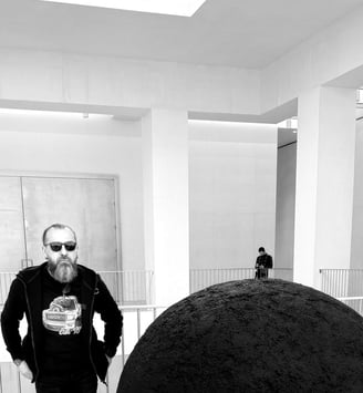 JEWELLER standing in front of a large black object