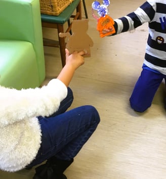 Photo de Magali Strassel, art-thérapeute, montrant deux enfants en trainde jouer aux marionnettes