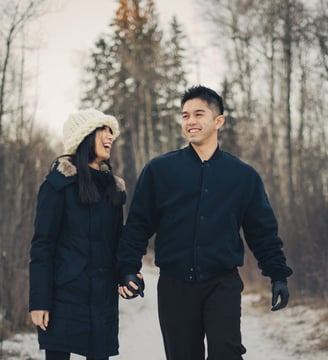 a photo of a man and woman holding hands and walking down a path