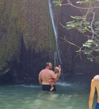 Vater und Sohn baden am Wasserfall