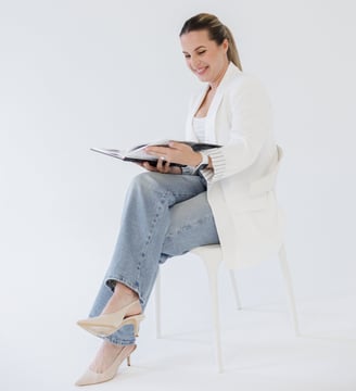 Bilde av grafisk designer Rasa June som sitter på en stol