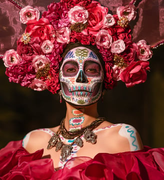 Pessoas celebrando o Dia dos Mortos com trajes tradicionais de caveira.