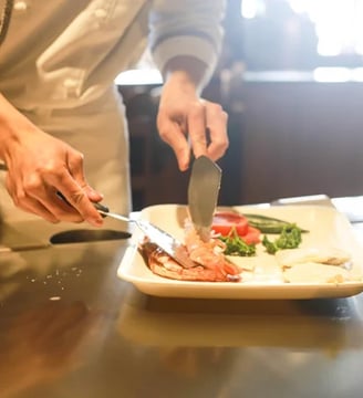 chef cuisinier qui montre le plat à faire pour un atelier cuisine à Montpellier