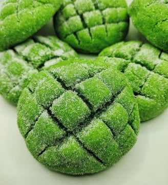 a plate of green cookies with sugared sugar on top