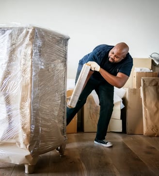 a man moving a couch with a mattress on it