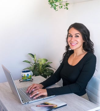 Woman typing on a laptop smiling