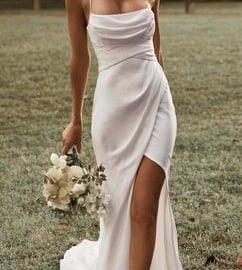 a woman in a white dress with a bouquet of flowers