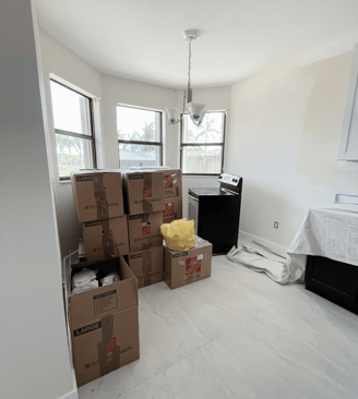 Packed moving boxes stacked in a bright kitchen space, ready for unpacking and setup.