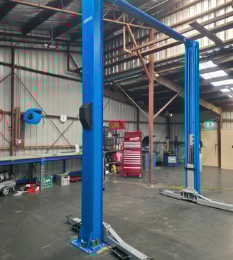 a workshop with a large hoist in the middle of a large warehouse