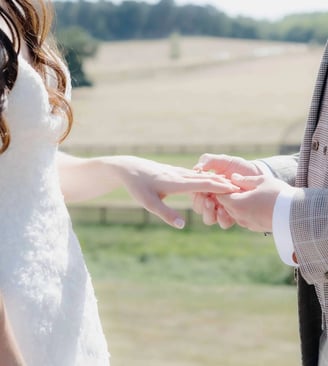 Groom placing a ring onto the finger of the bride