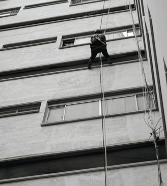 a teddy bear climbing up a tall building