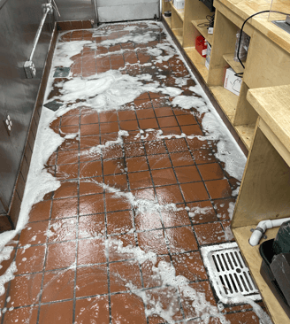 a restaurant tile kitchen floor with soap on it