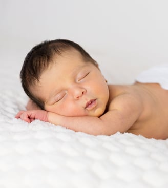 Sessió de fotos newborn a Girona amb una bebè recent nascuda dormint en estudi fotogràfic