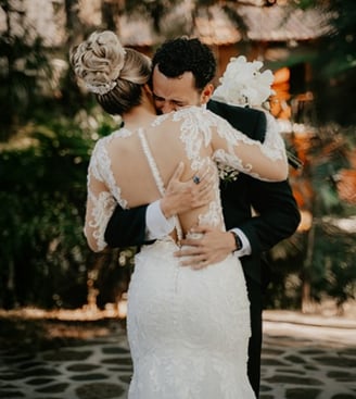 Novio abrazando a su novia después de verla por primera vez con su vestido de novia blanco - Aldo Bo