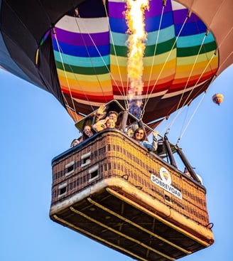 Voo de balão compartilhado repleto de família feliz sobrevoando Praia Grande-SC