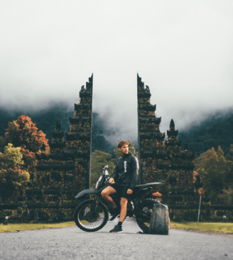 a man sitting on a motorcycle with a suitcase and luggage