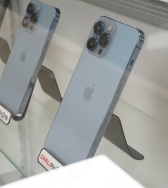 a display case with several different types of cell phones, computers and more