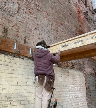 a man is working on a beam of wood