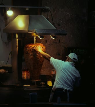 a man is cooking/heating meat for Street Local tacos at Tacos Mixes Los Angeles