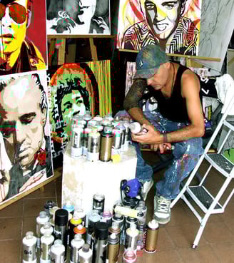 Artista Sérgio Astral pintando quadros personalizados em seu ateliê.
