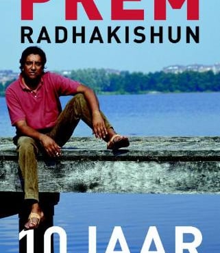 a man sitting on a wooden bench in front of a lake