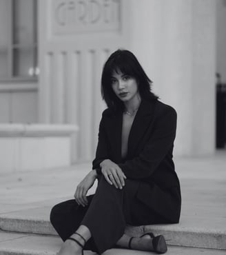 a well dressed woman with high standards wearing heels sitting outside a building