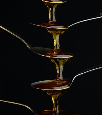 Molasses trickling down teaspoons