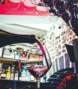 a wine glass being poured with wine