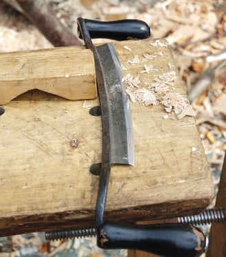 a drawknife on a wooden table