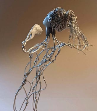 A wire sculpture of a complete kneeling female figure with clay hands, face and feet, arms raised