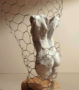 A clay female torso surrounded by wire netting, painted in neutral colours