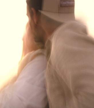 Photo artistique d'un couple habillés en beige à la lumière d'un coucher de soleil.