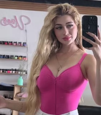 a woman in a pink top and white pants