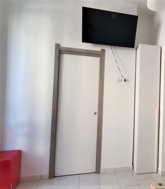 a bedroom with a television and a television