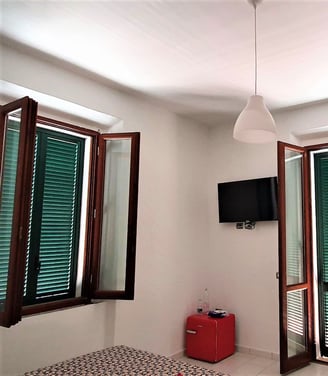 a room with a television and a red suitcase