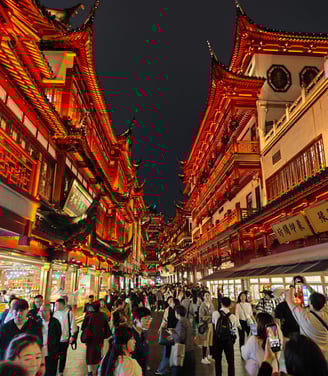 Glowing red buildings alongside busy street
