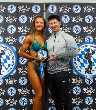 eine bikini wettkampfathletin mit ihrer neu gewonnen medaille auf der bayrischen meisterschaft