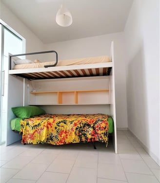 a bunk bed with a colorful bed and a yellow blanket
