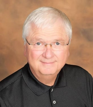 white haired man in a black shirt and glasses