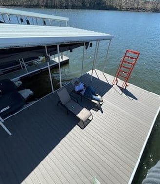 a man sitting on a dock with a chair and a ladder