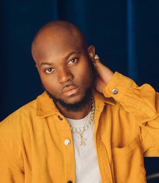 King Promise in a brown vest.