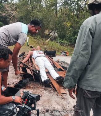 a film crew hard at work shooting a man in a white shirt