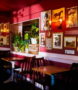 The snug area, with sorbet pink wall and lots of different quirky images and photos on the walls
