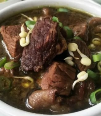 rawon linda a bowl of soup with meat and vegetables