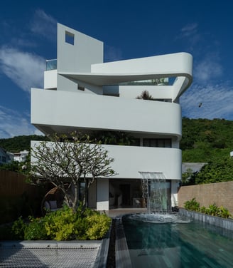 a house with a waterfall in the middle of the pool
