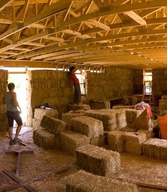 a group of people working on hay bale bale