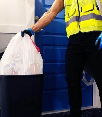 Valet trash service taking out the trash from in front of a resident's door.